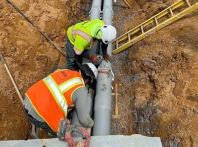 Utility pipe being installed in an open trench