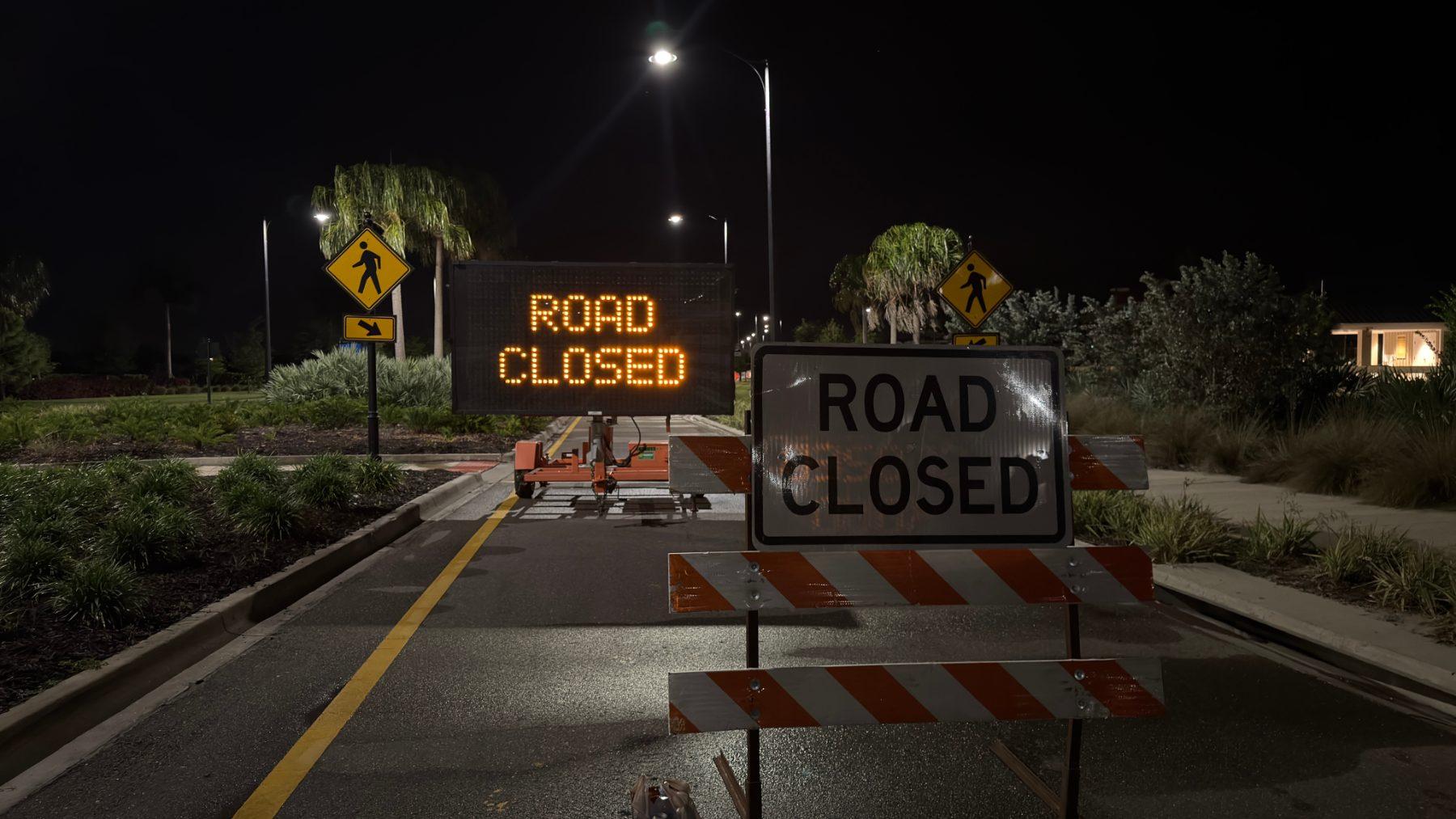 Road closed signs at a nighttime roadway work zone