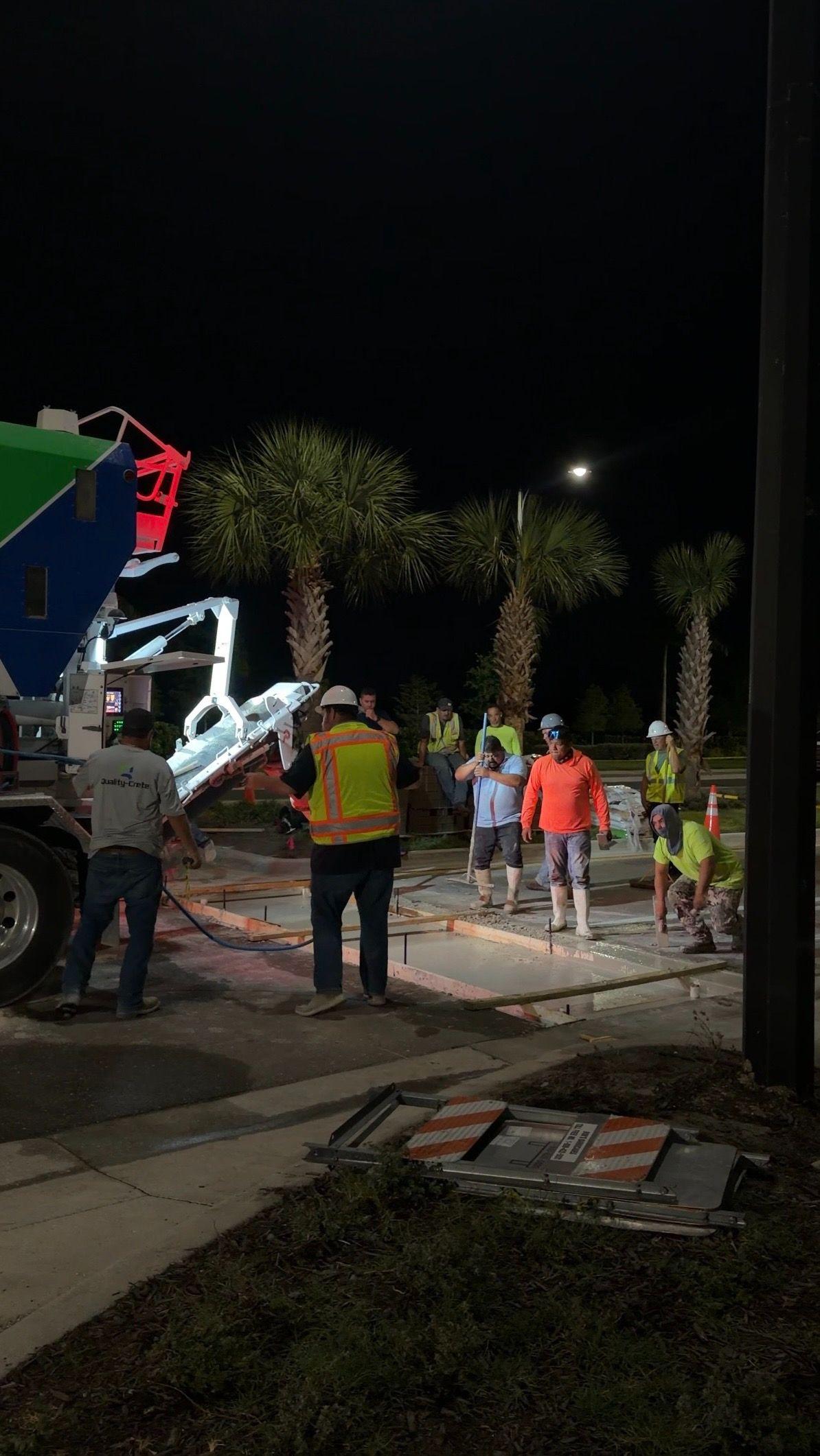 Night-time road repair crew placing rapid set concrete