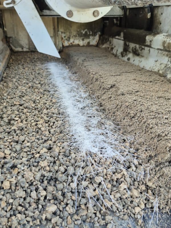 Concrete flowing over aggregate from a mixer chute