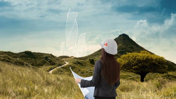 Engineer reviewing plans on a green hillside site
