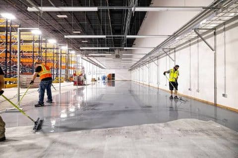 Warehouse interior with crews finishing a new slab