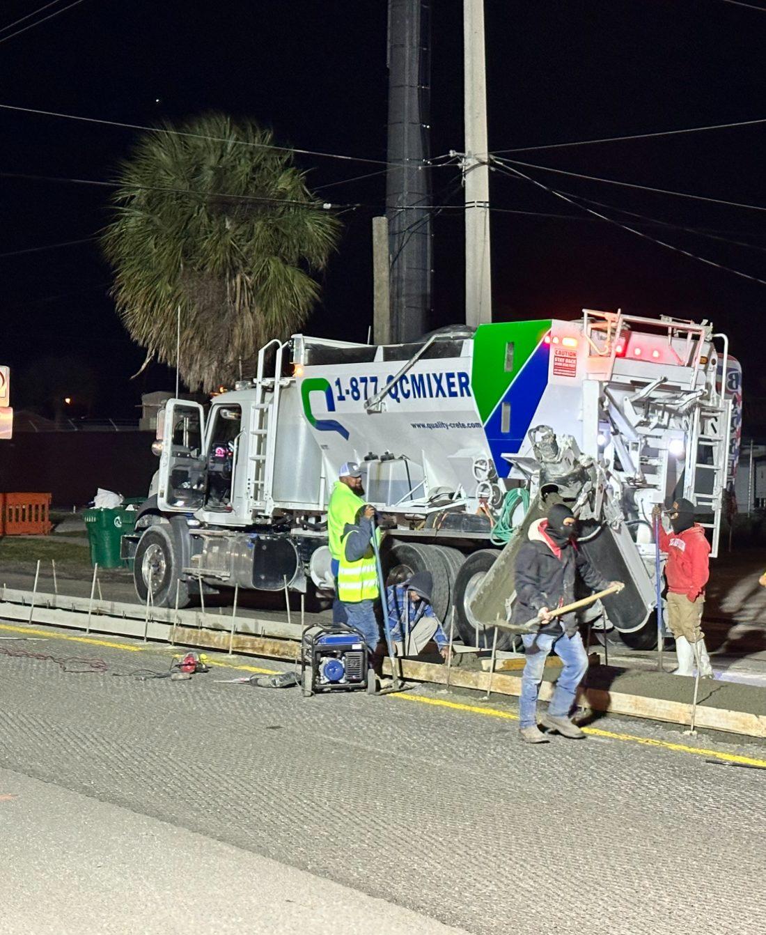 Quality-Crete mixer and crew on a night roadway pour