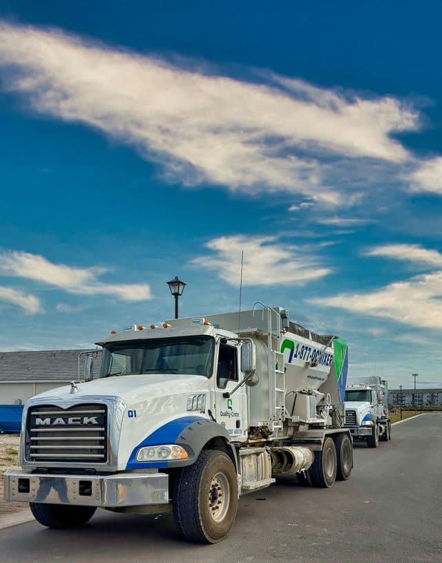Quality-Crete volumetric mixer truck under a blue sky