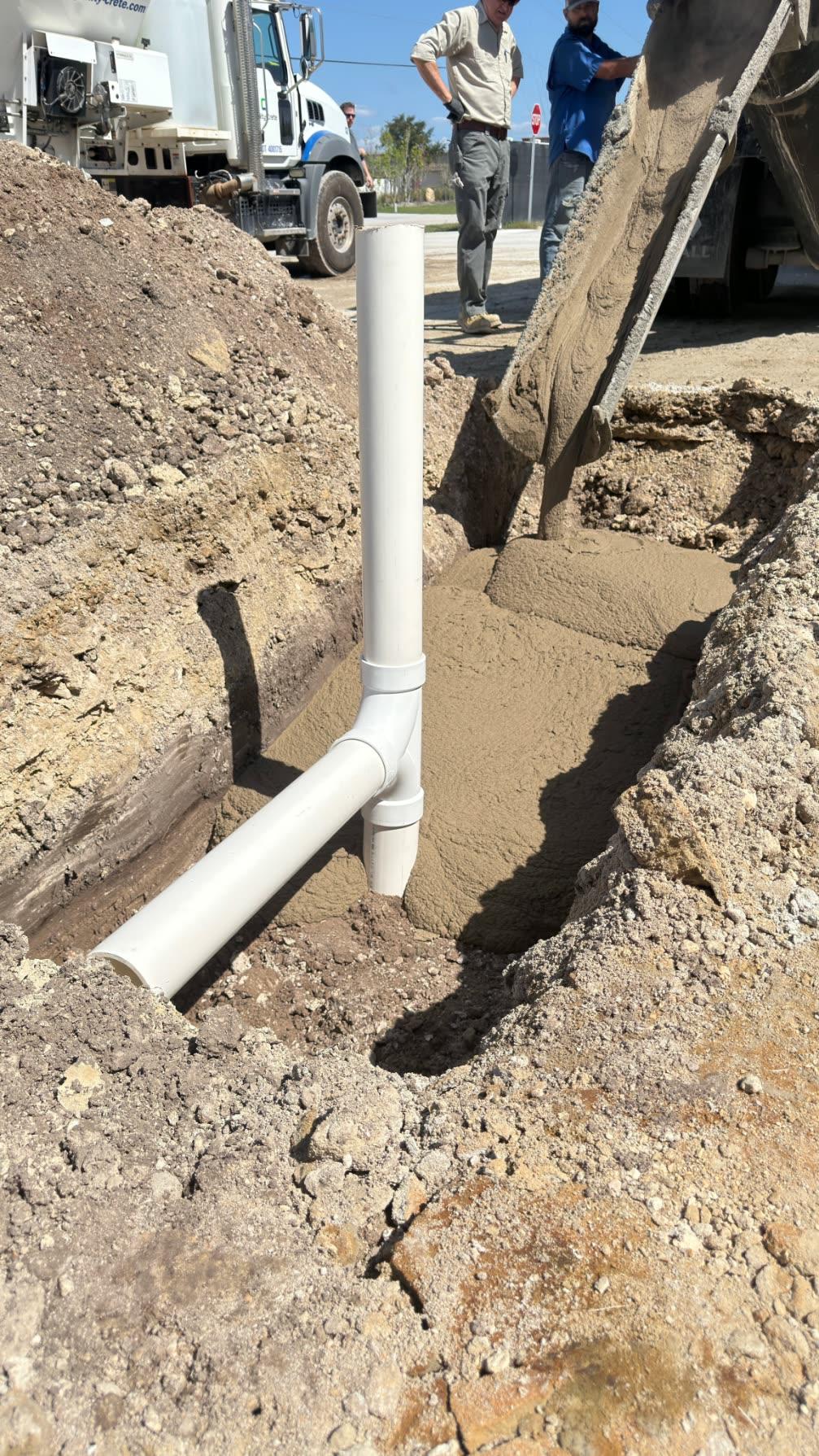 Fast setting flowable fill being discharged into a trench