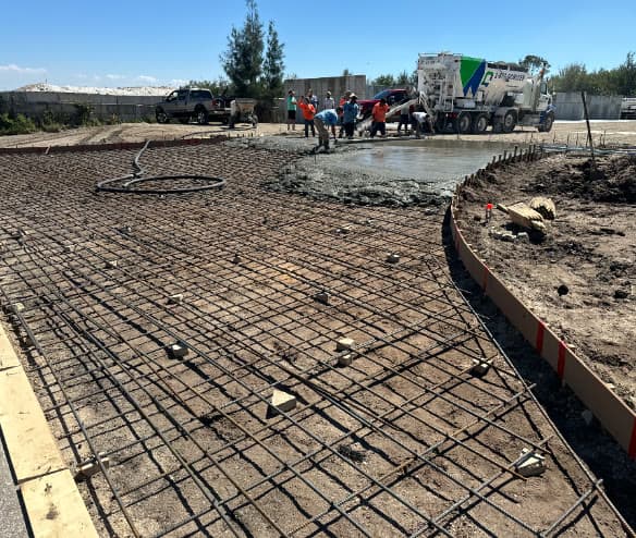 Crew finishing a freshly placed concrete slab