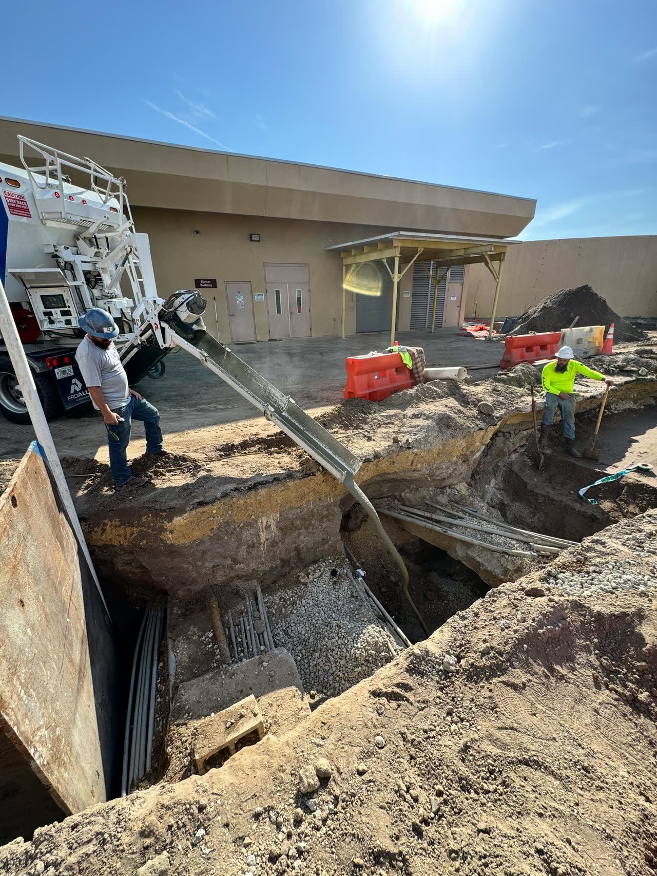 Flowable fill being discharged into an open utility trench