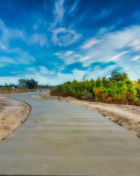 Freshly poured concrete path under a blue sky