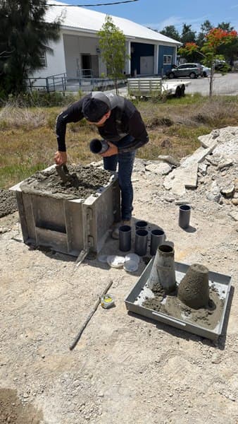 Worker finishing a formed concrete pour outside a house