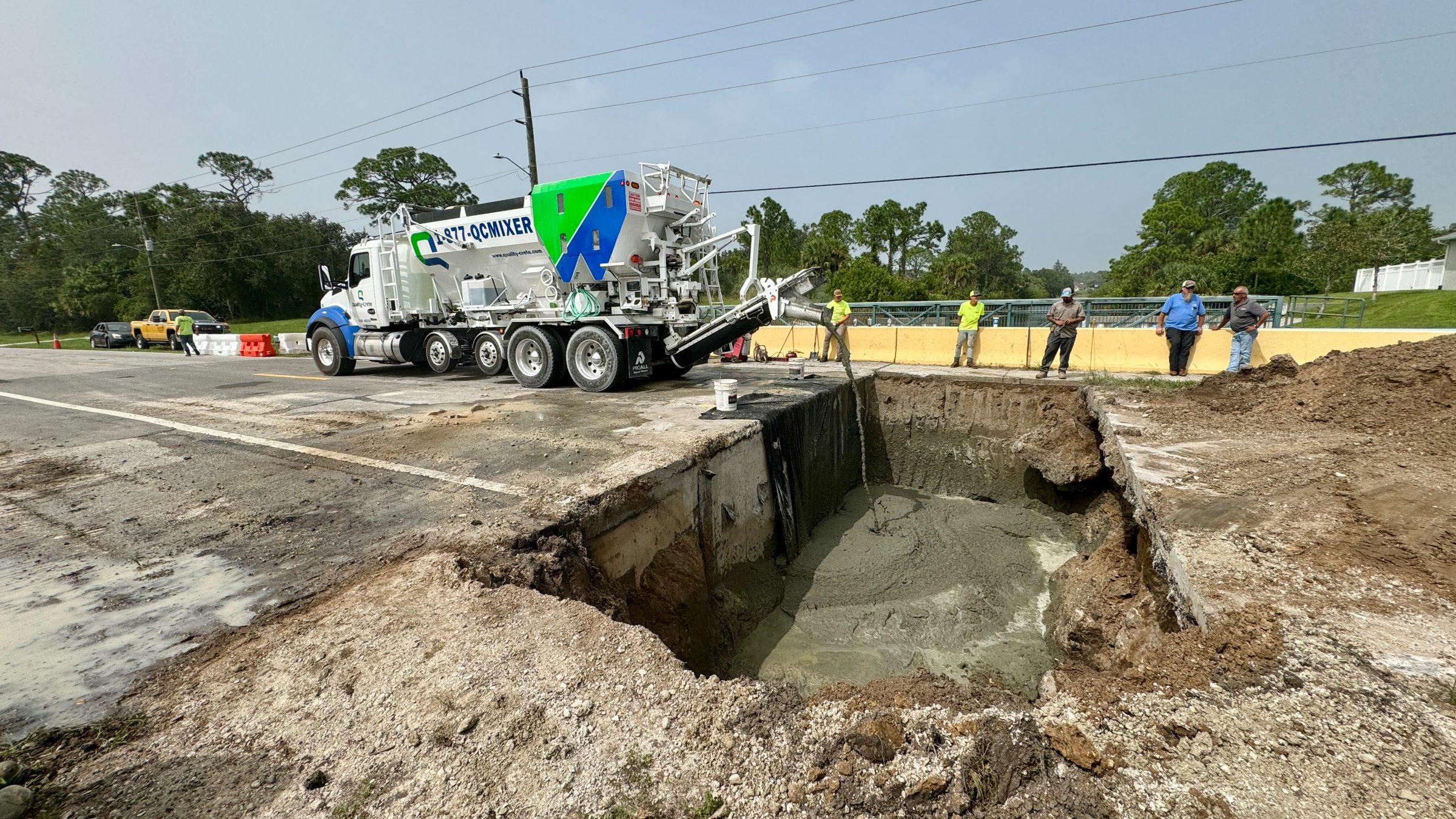 Quality-Crete mixer beside an open excavation