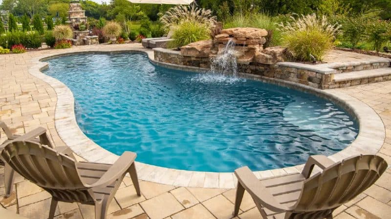 Backyard pool with a stone waterfall feature
