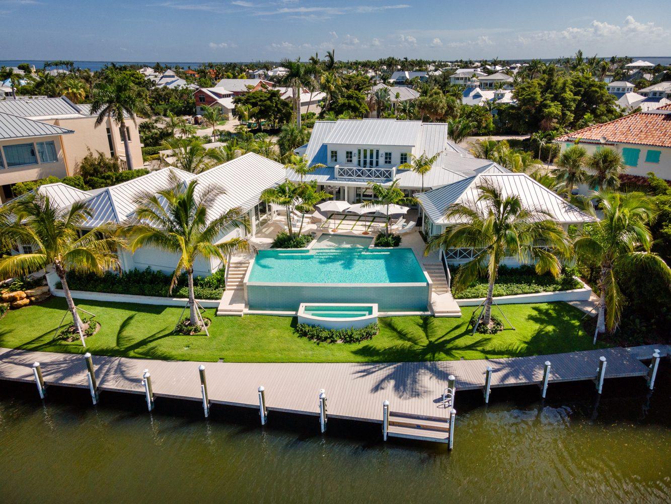 Aerial view of a waterfront home with a backyard swimming pool